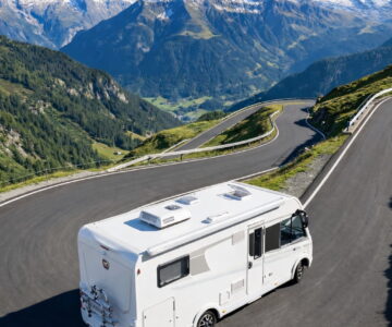 Autocaravana blanca en carretera de montaña con curvas